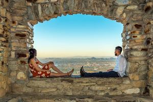 A couple sit on a rocks